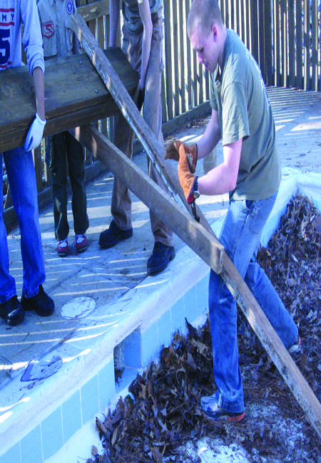 Senior Robert Scheible disassembles a collapsing shade shelter for a community service project. Scheible reinfornced the fences to keep out vandals, and built another shelter that was higher off the ground, more stable, and better looking. 