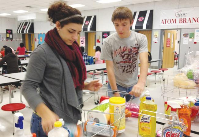 Seniors Susie Sowa and Reid Moore compile baskets for Homestretch. They are members of NHS. 