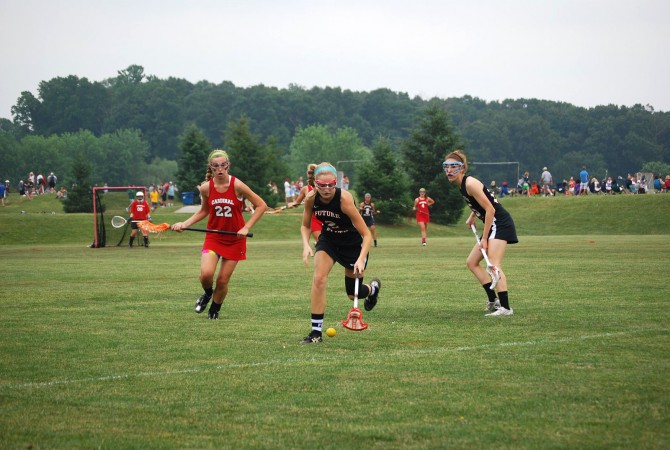 Wright (center) goes to recover a ground ball in a tournament game with her Future Elite Lacrosse Team. 