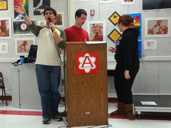 NHS members Harris Fitzgerel, Stephen Oakes, and Madeleine de Mello make announcements during the meeting.