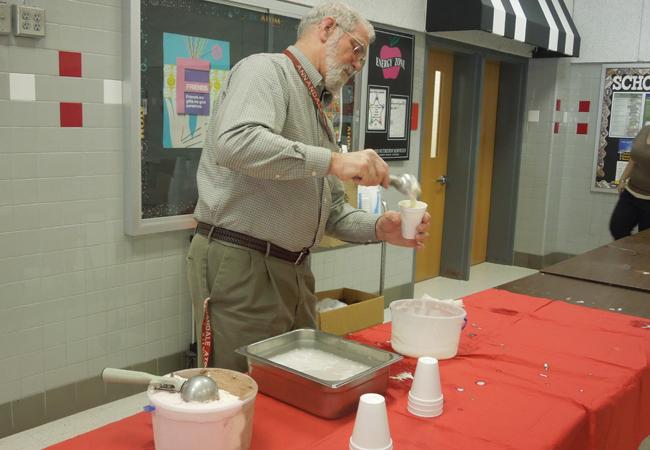 Teacher gladly serving ice cream to students who exceeded in their classees
