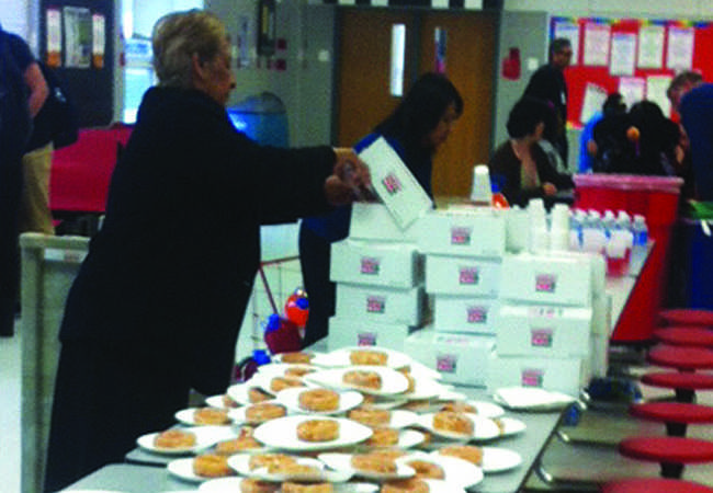 Teachers organize Krispy Kreme doughnuts in preparation for the honor roll breakfast.