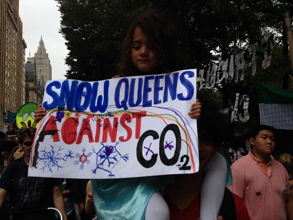 A young girl dressed as Princess Elsa from Frozen protests climate change. 