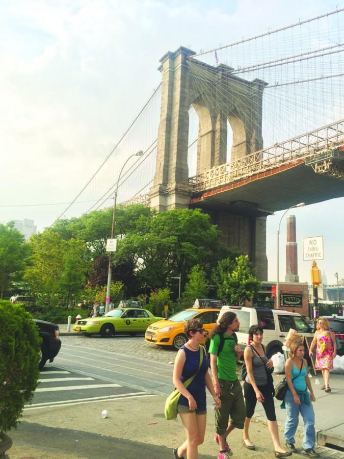 Tourists explore the artistic design of the Brooklyn Bridge, an icon and historical site in New York City.