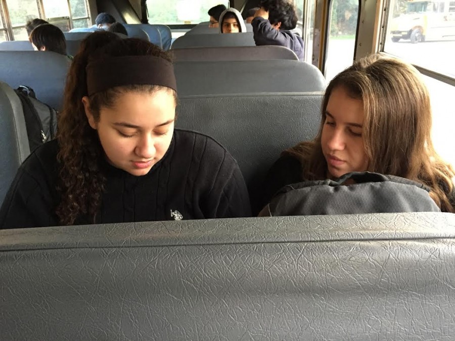 Two students chat on the bus prior to departure