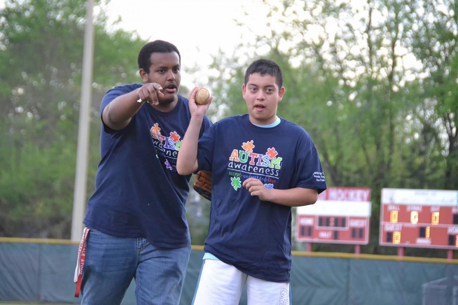 Student Ricky Portillo (Right) throws out an opening ceremonial pitch on Autism Awareness Night on April 21 with Mr. Khalid Mohamed. 