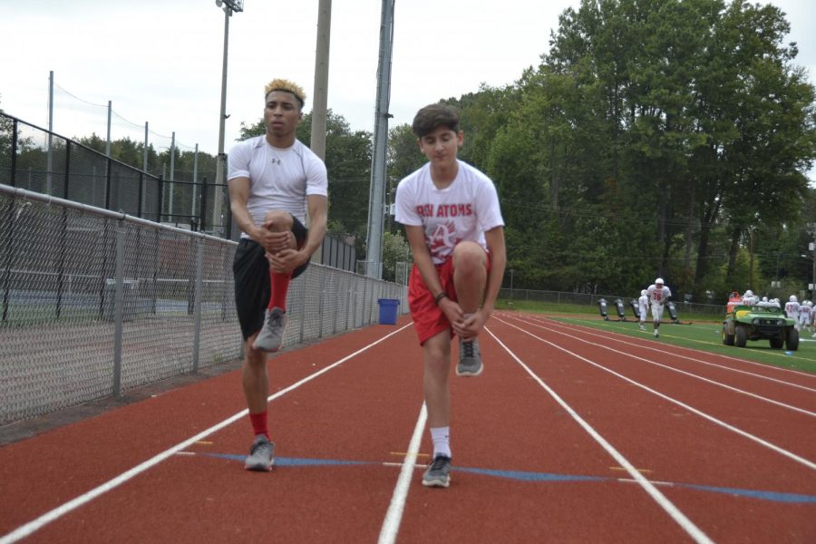 Jay Pendarvis (Left) and Tarik Darwiesh (Right) stretch in order to prepare for a run during a Green Day for track. 