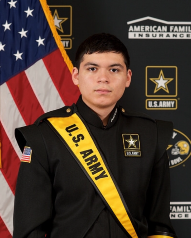 Angel Estrada is posing in his official US Army Marching Band uniform.