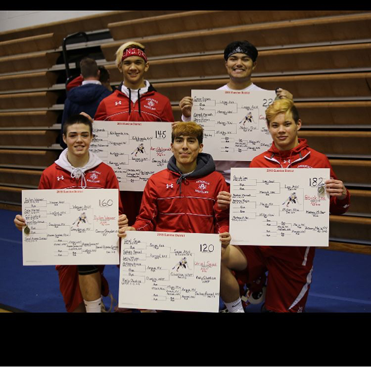 (Left to right) Dylan Weaver, Allen Kokilananda, Uriel Sejas, Cesar Lopez, and Patrick Lee pose with the tournament brackets showcasing their first place finishes at the Gunston District Championships.
