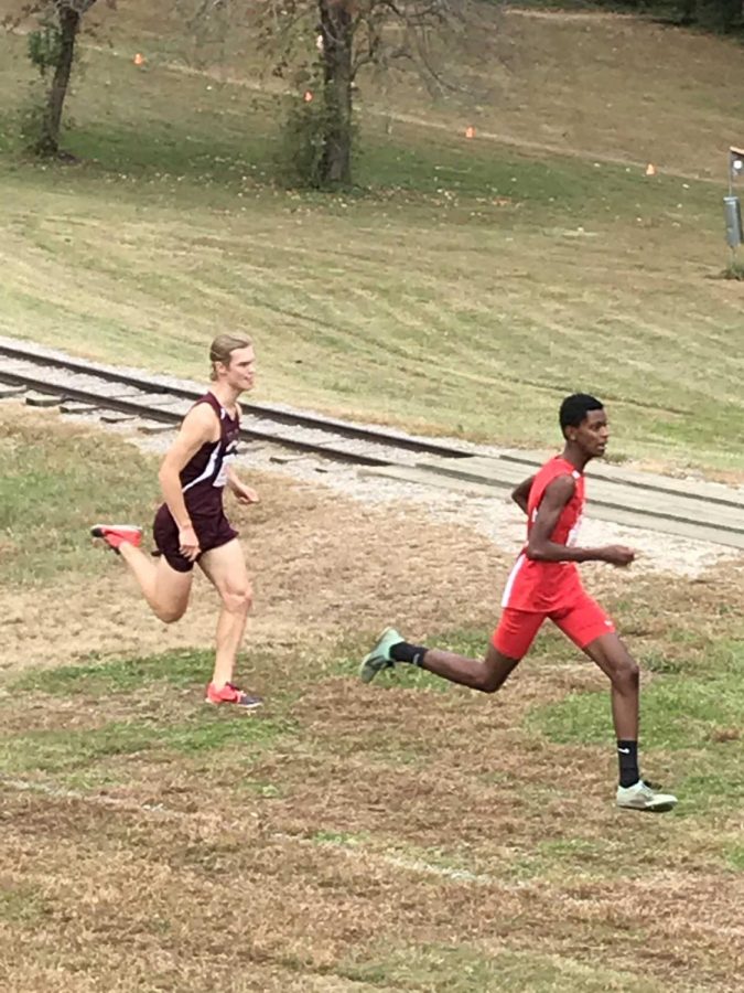 Junior Mikyas Sahlu kicks away from Mount Vernon’s senior runner, Hunter Fowlie, during the end of the race to win the Gunston District Championship. 
