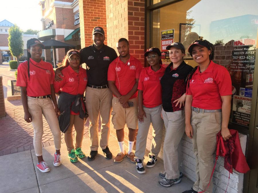 Senior Hemen Besufekad (right) stands in front of Papa Johns, where she worked for the summer, with her coworkers.