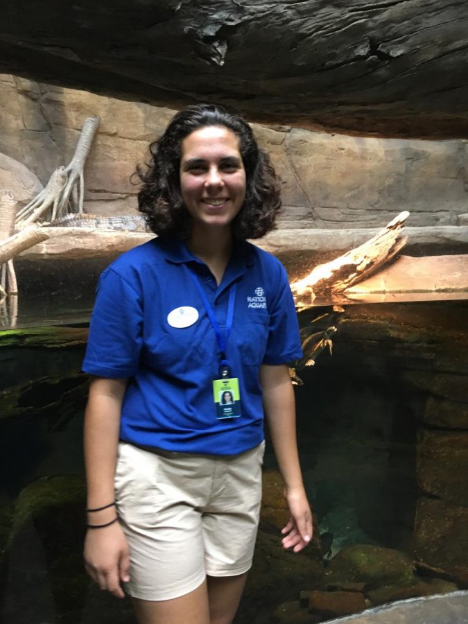 Junior Emily Shawish stands in front of an exhibit in the National Aquarium, where she works as a  
volunteer exhibit guide.