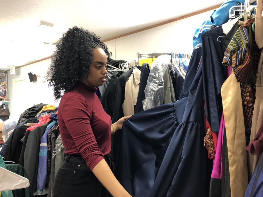 Senior Hemen Besufekad looks at donated prom dress in the Parent Resource Center. Pop-up shop will begin Wed. March 20 from 3 p.m. to 6 p.m. and Thurs. March 21 from 6 p.m. to 8 p.m.