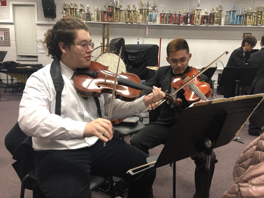 Junior viola player Freddy Henriquez-Pinzon and sophomore viola player Matthew Kim practicing Waltz No. II by Dimitri Shostakovich, Arr. By Paul Lavender, beofre perfoming on stage. “I like Waltz No. II because it’s a very technical piece and it’s fun to play,” Henriquez-Pinzon said.