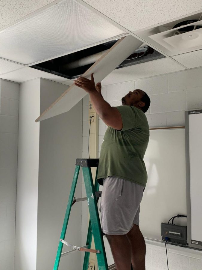 Instructional assistant Khalid Mohammed fixes the ceiling in an AHS classroom. Many improvements have been made around AHS to prepare the school for when students come back.