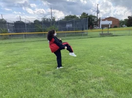 Freshman Sibyl Dauer practices her martial arts skills in an empty field.