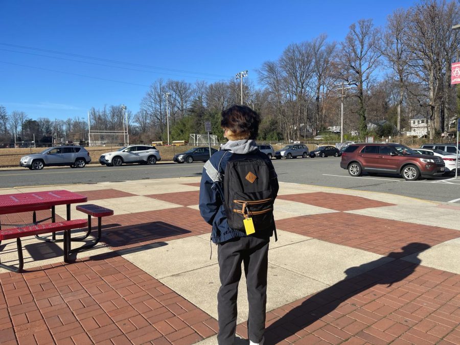 Senior Kyle Ho walks out of AHS during his free period with a yellow ID tag. 