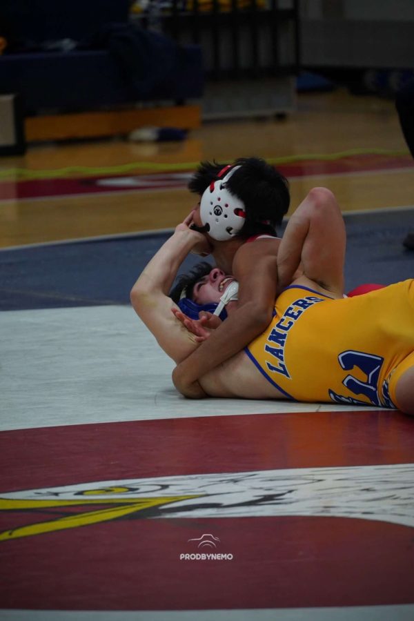 Junior Marcelo Pozo takes down an oppponent from Lewis in an invitational tournament.