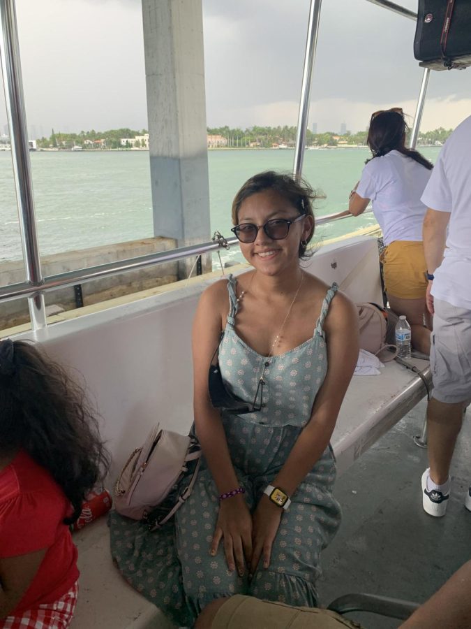 Cinara Galindo sits on a boat traveling over a lake in Miami.