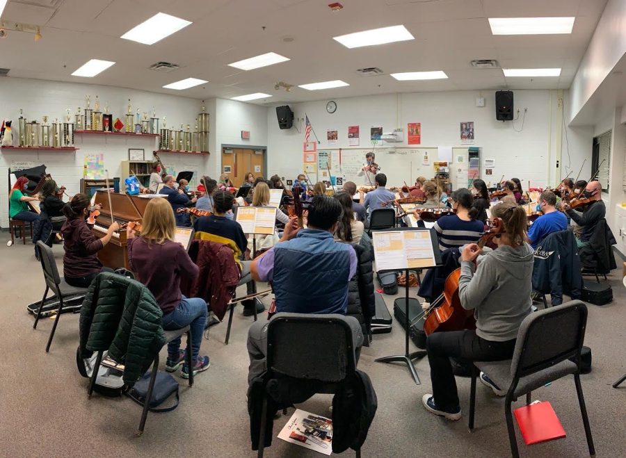 Orchestra teacher conducts parent ensemble
