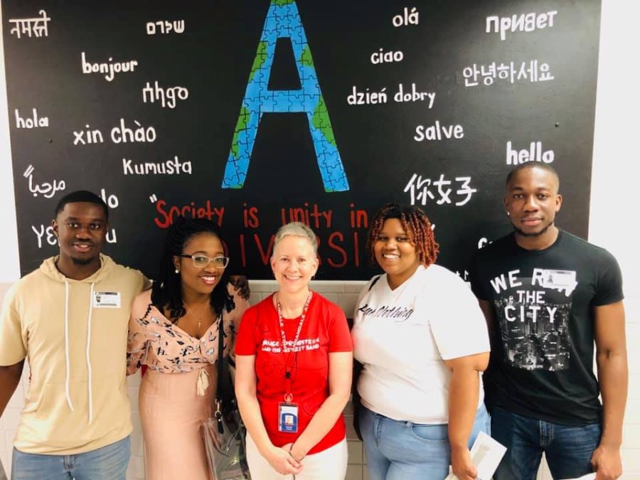 English teacher Bonnie Vining (center) takes a picture with former students.