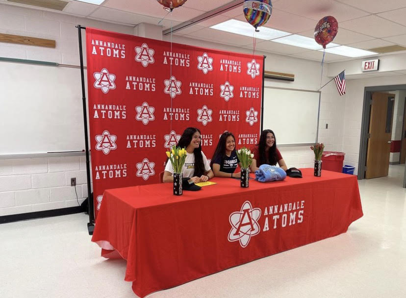 Seniors Madeline Dosen, Daniela Dosen, and Camille Cortes celebrate their commitment to play college soccer during a signing ceremony.