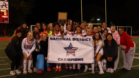 The Atoms Field Hockey team holds the district title banner after defeated the Justice Wolves on Oct. 19.