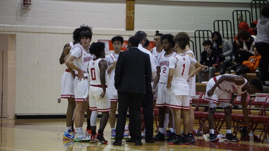 The boys basketball team discusses the game plan to defeat Falls Church in a game last season.