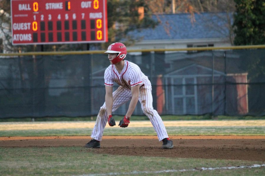 Junior TK Decareau takes a lead off of fi rst base after getting a base hit against Thomas Jefferson on April 1. The Atoms won 9-6 in seven innings.