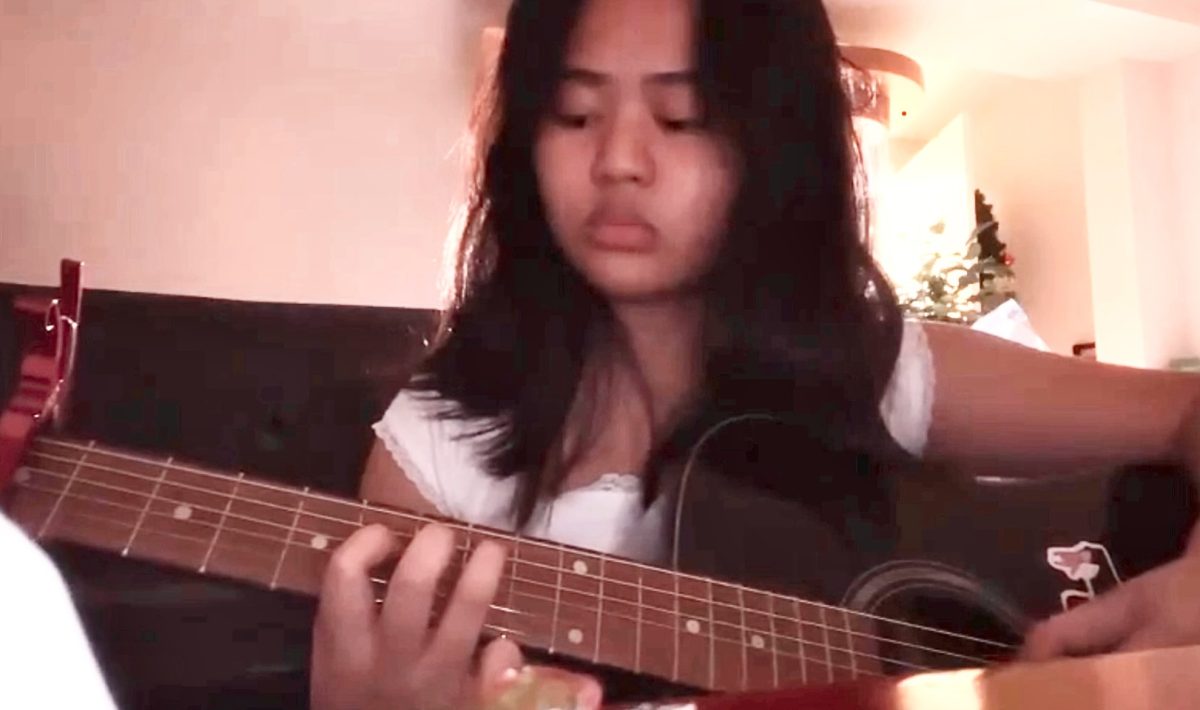 Jyzel Raquepo playing on her personal guitar.