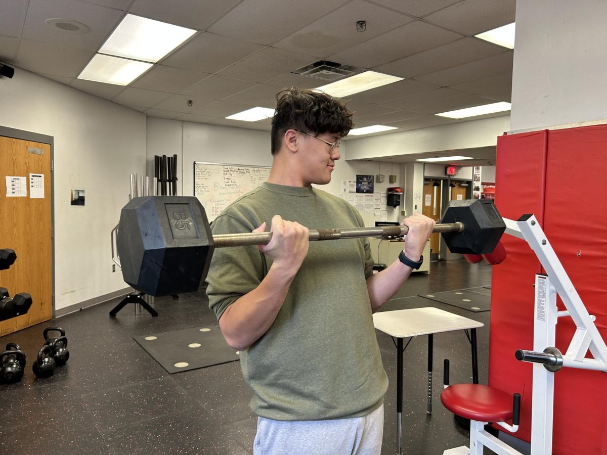 Senior Raymond Lam shows off his gains by staying consistent in the weight room as he curls his max weight.