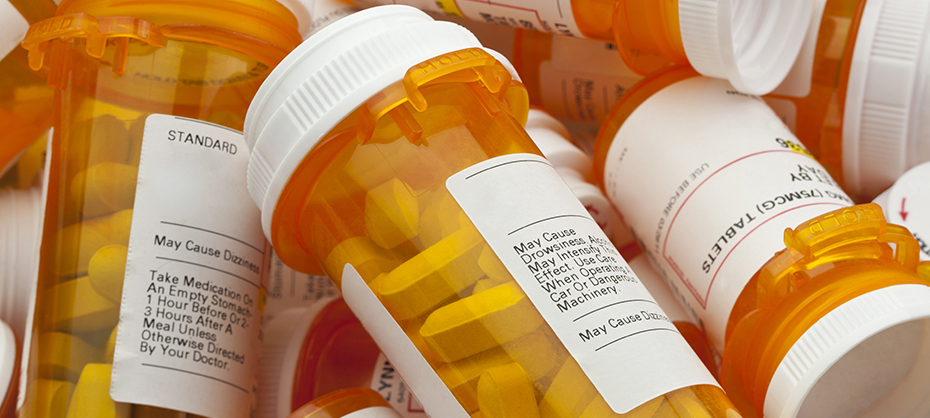 Bottles of prescription medicine in a pile. This collection of pill bottles is symbolic of the many medications senior adults and chronically ill people take.