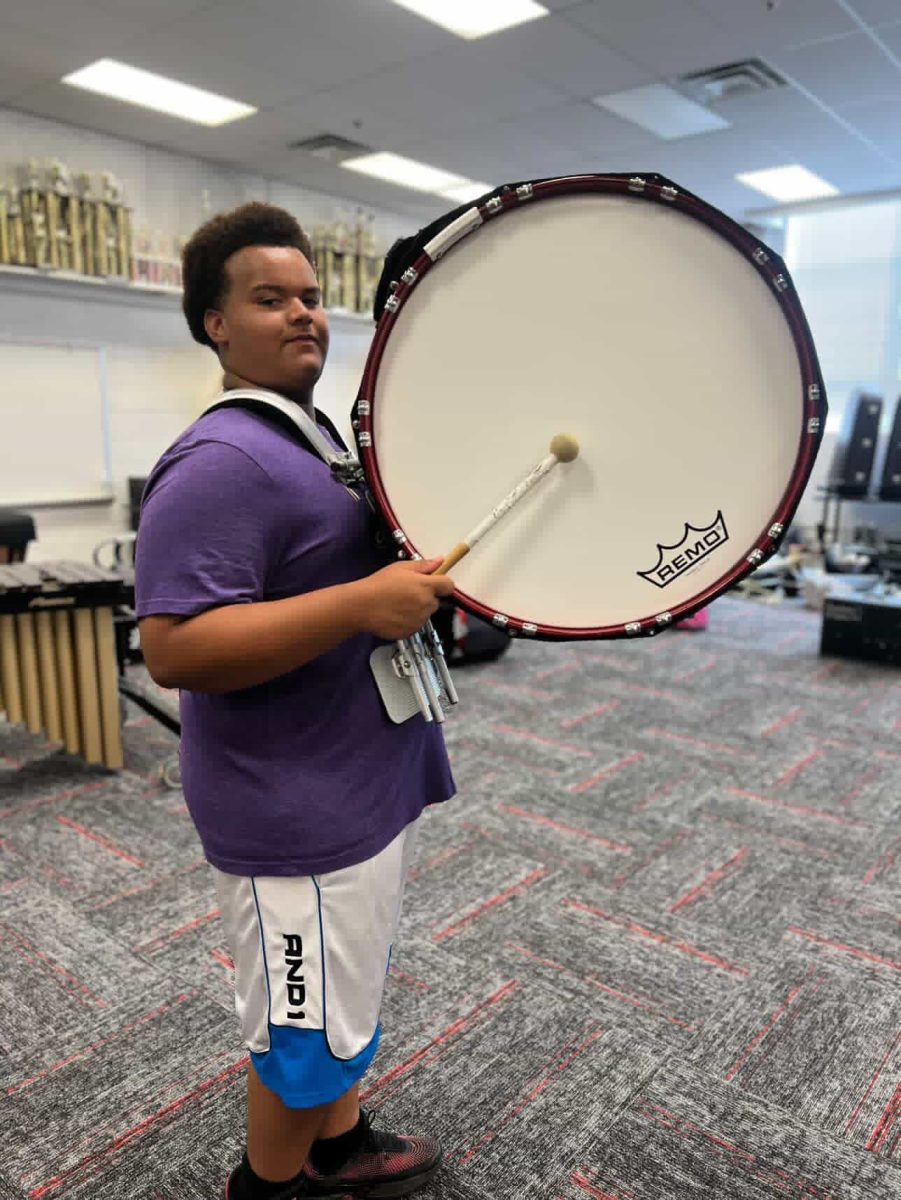 Estudiante Braden Meredith, quien originalmente toca la tuba, probando el bombo durante un descanso de práctica de marcha en el salon de banda de AHS