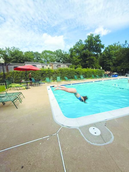 Junior Molly Corcoran dives into one of her local pools in the summer of 2024.