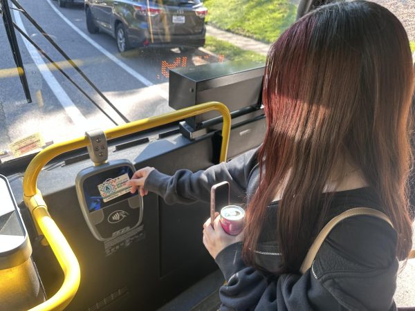 Junior Diana Gutierrez scans her student bus pass on a Fairfax County METRO bus to go to her home after a school day. 